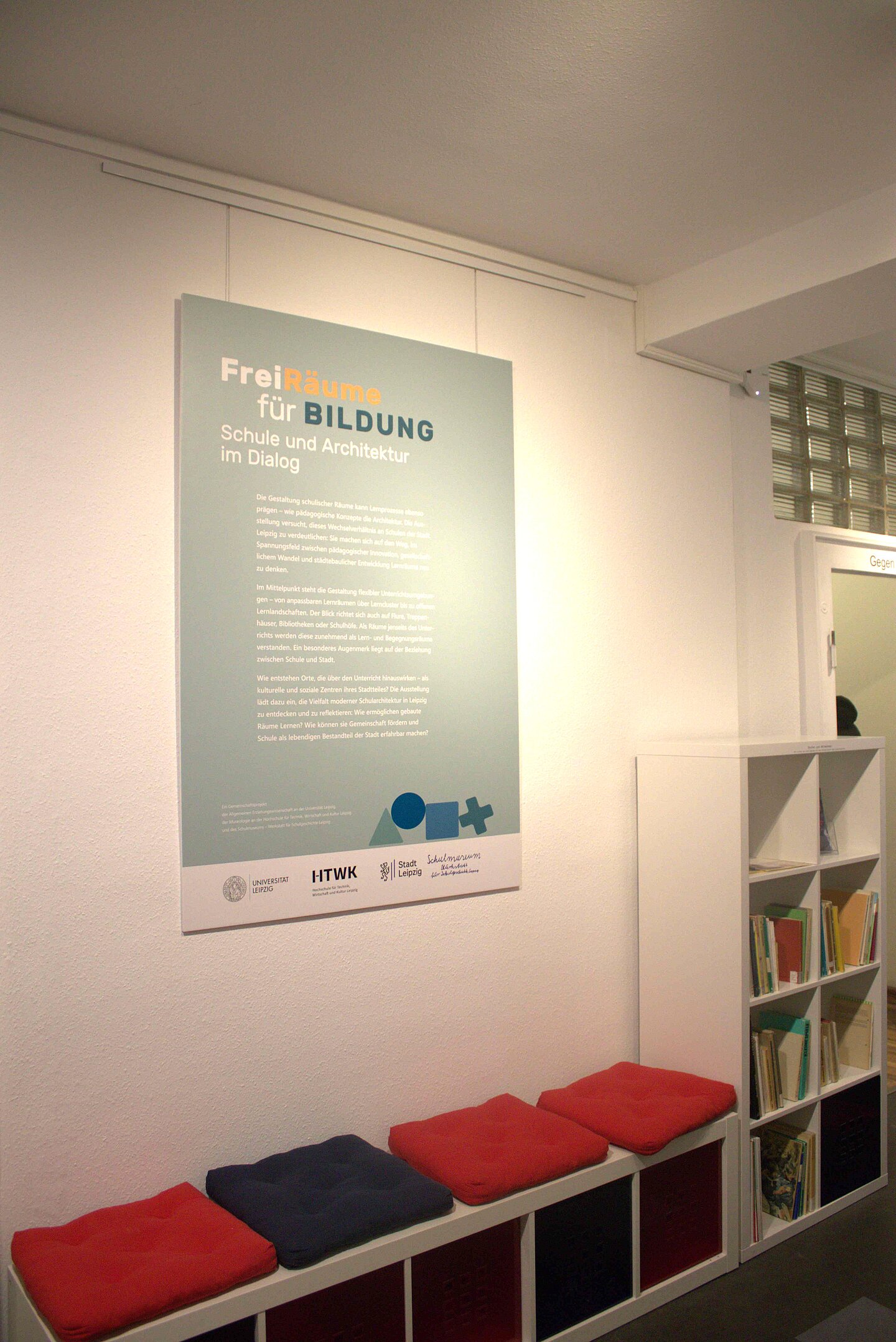 Sitzbank unter einem Plakat als Teil einer Ausstellung